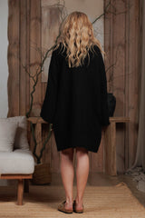 Back view of a short black muslin robe, designed for the warm climates of Dubai, UAE, and GCC. The breathable and lightweight fabric makes it perfect for beach cover-ups, resort wear, and relaxed home styling. Photographed in a minimalist, nature-inspired setting, reflecting sustainable Middle Eastern elegance.
