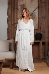 Front view of a long white linen kimono, elegantly tied at the waist for a flattering silhouette. Perfect for beach cover-ups, summer city strolls, and resort getaways in Dubai and GCC. Crafted from natural linen, it ensures breathability and comfort in warm climates.