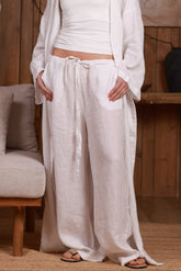 Close-up of white linen trousers with a relaxed fit and drawstring waist, perfect for summer style in the UAE and GCC. The breathable natural linen fabric offers comfort and elegance, ideal for beach outings, casual wear, and resort looks.