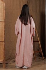 Back view of a long muslin women's shirt in tea rose color, showcasing the relaxed fit and soft texture. Ideal for layering over swimwear or casual summer outfits, designed for comfort and style in the Gulf region