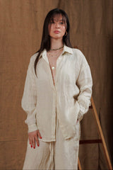 Front view of a woman dressed in a beige linen shirt paired with matching wide-leg linen pants. The natural texture and lightweight design are perfect for the hot climates of the Middle East, providing comfort and elegance for beachside walks or city outings in Dubai.