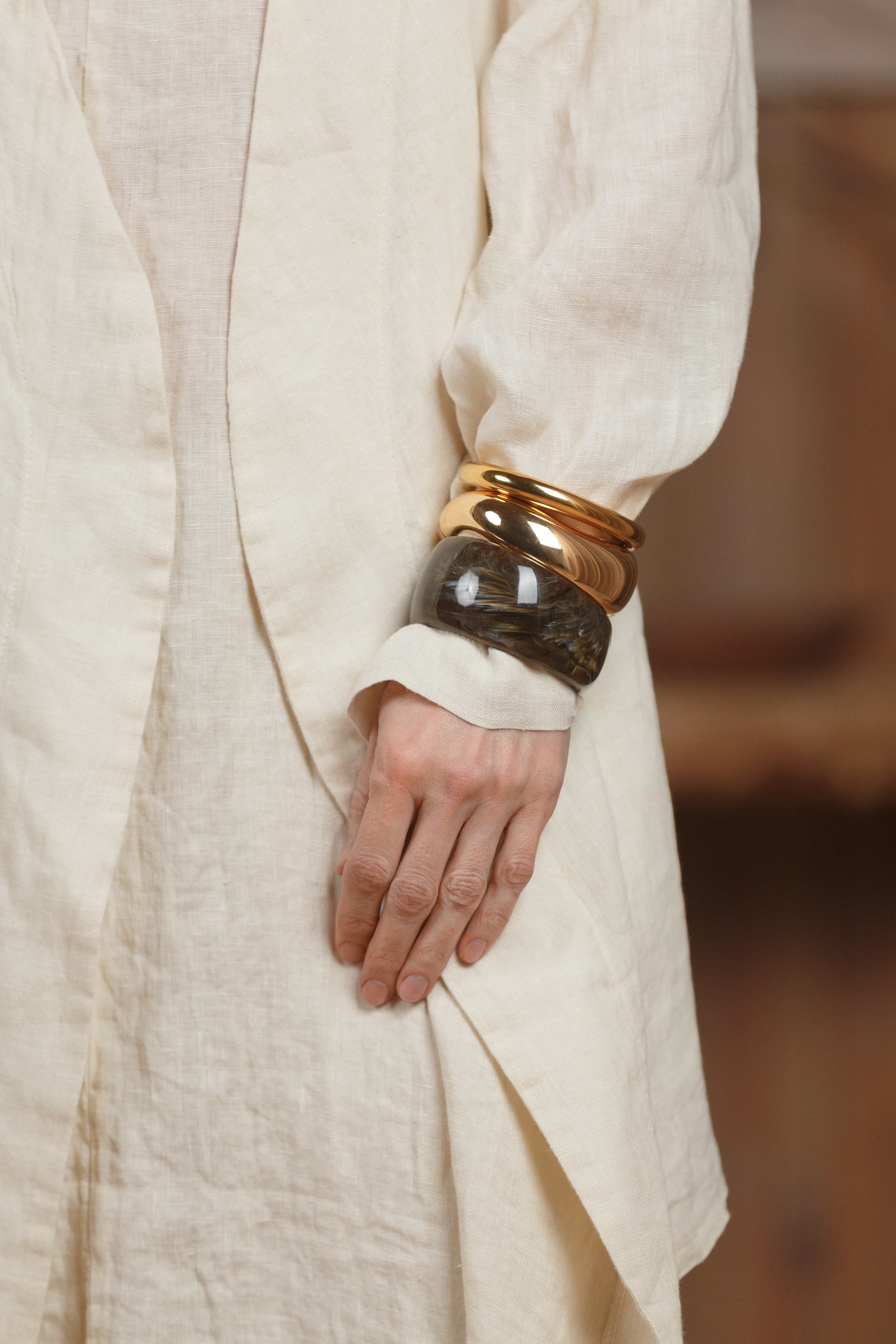 Close-up of the sleeve and texture of the beige linen kimono. High-quality linen fabric ensures durability and comfort, ideal for the hot weather of the UAE and GCC region. Paired with golden accessories for a touch of elegance.