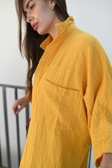 Close-up of a long amber muslin shirt featuring a front pocket and textured fabric. The breathable muslin material makes it an ideal choice for hot climates, showcasing sustainable fashion in the UAE and GCC markets.