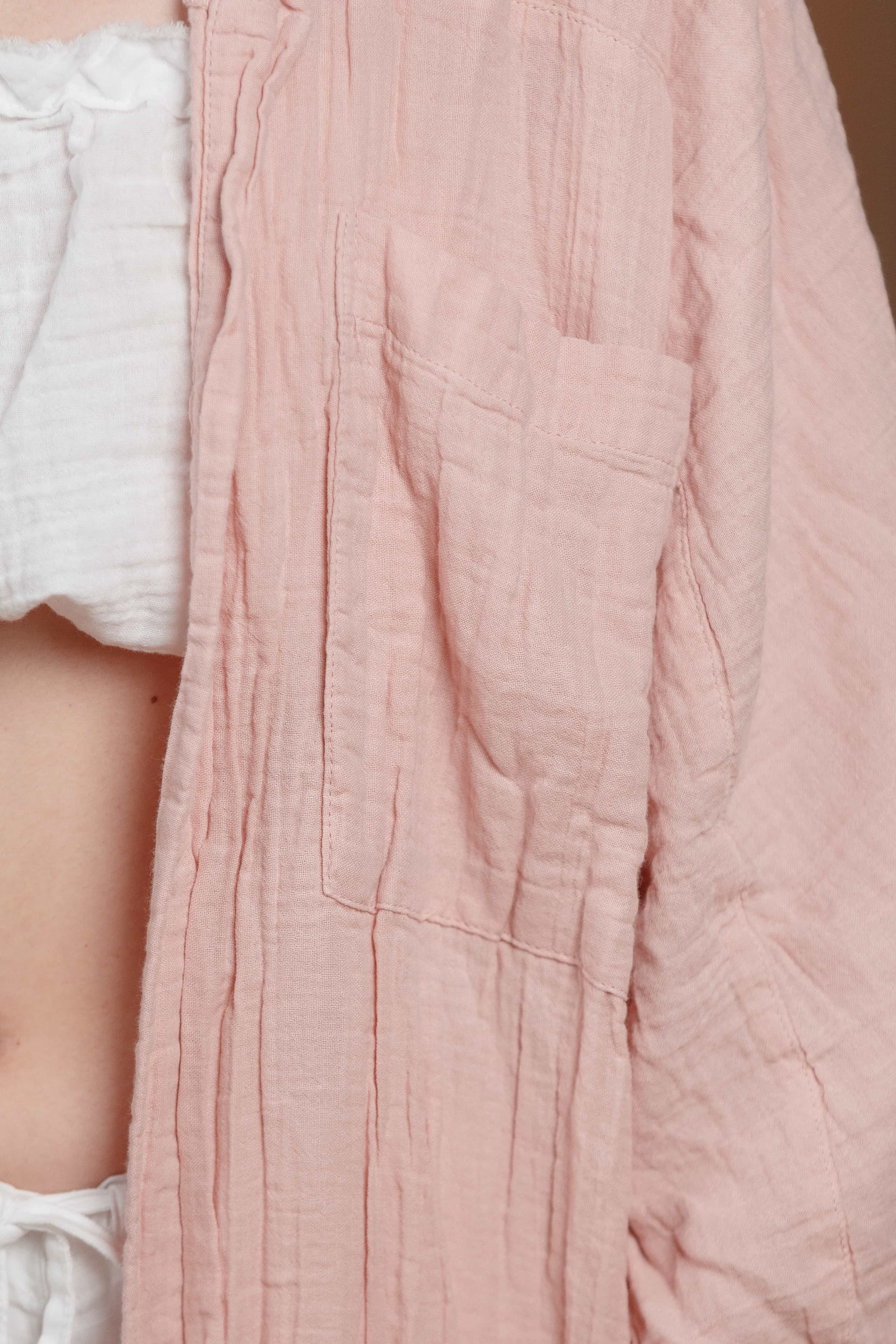 Close-up detail of the textured muslin fabric and front pocket of the long women's shirt in tea rose color. The breathable material is perfect for warm climates, offering both comfort and style for summer fashion in the UAE and GCC countries
