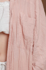 Close-up detail of the textured muslin fabric and front pocket of the long women's shirt in tea rose color. The breathable material is perfect for warm climates, offering both comfort and style for summer fashion in the UAE and GCC countries